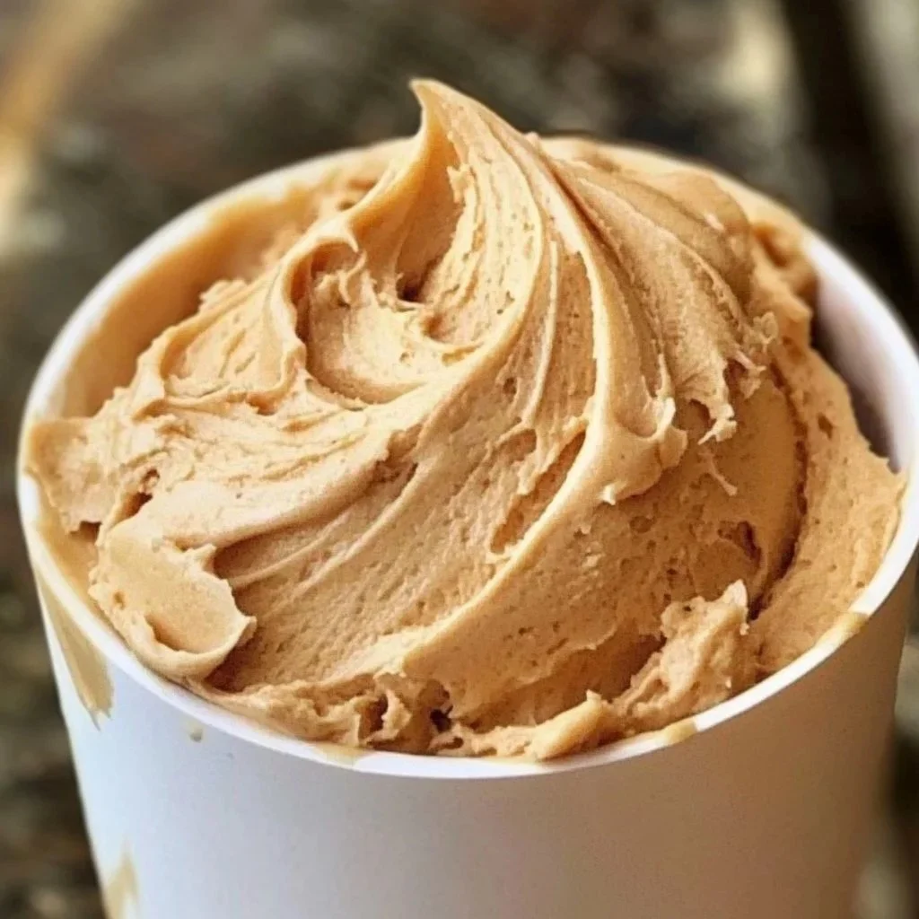 Creamy homemade peanut butter frosting in a bowl with a spatula